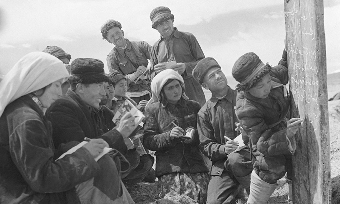 1960年6月，新疆慕士塔格峰下，大人們在小學生幫助下學習文化。新華社記者武純展攝