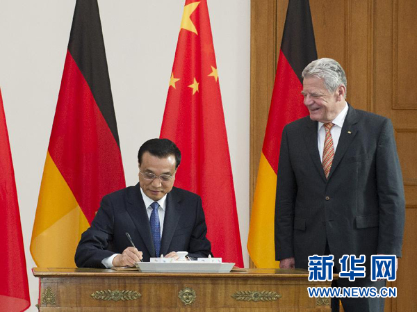 10月10日，國務(wù)院總理李克強在柏林會見德國總統(tǒng)高克。這是李克強總理在高克總統(tǒng)的陪同下在貴賓簿上簽字。 新華社記者 王曄 攝 